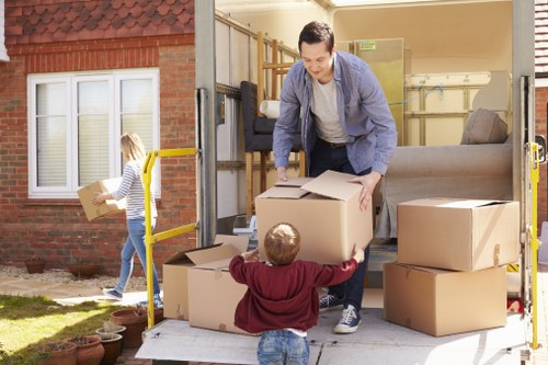 Professional movers loading items into a van on a Highbury street